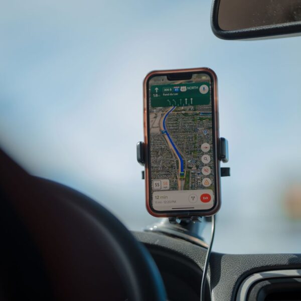 Móvil con un mapa de navegación en el salpicadero del coche: anuncios en Google Maps