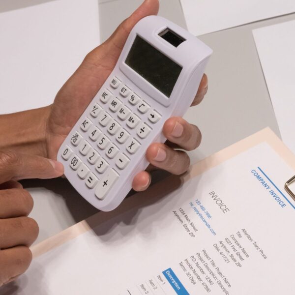 Persona calculando con una calculadora sobre una factura el precio del SEO local