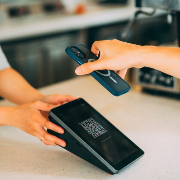 Cliente escaneando con el móvil un código QR en el mostrador para dejar una reseña en Google