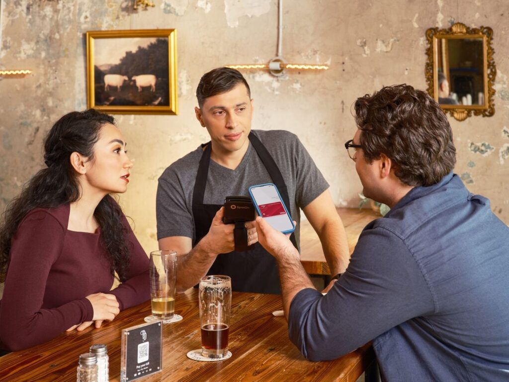 QR y enlace para reseñas de Google: cómo crearlos y dónde ponerlos (2026) 3 Camarero atendiendo a unos clientes en la mesa de un bar: el momento de pedir la reseña