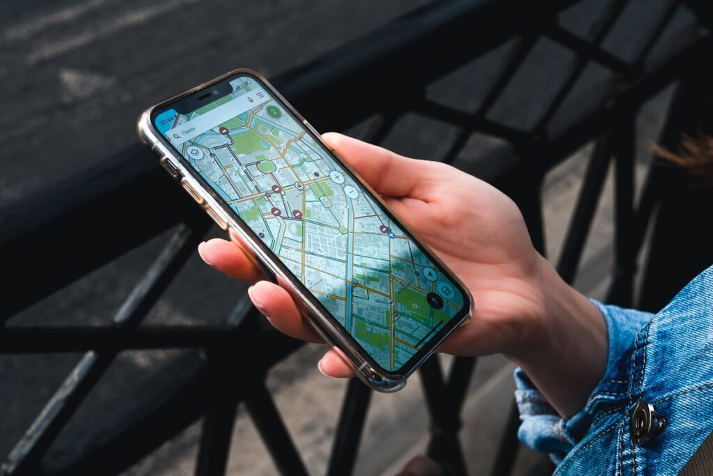 Mano sujetando un móvil con un mapa abierto: ficha de empresa en Bing Maps