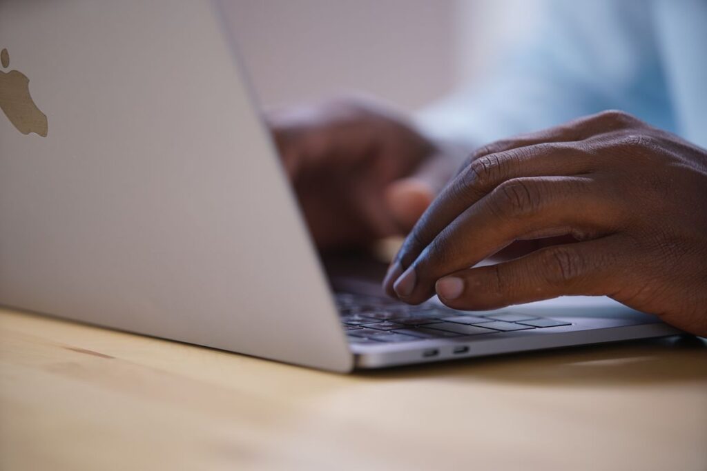 Manos escribiendo en un portátil: verificación de fichas de varias sedes en Bing Places