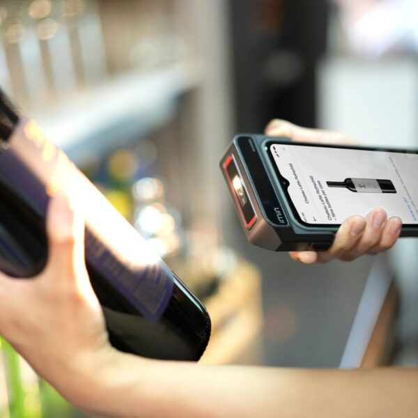 Empleada escaneando una botella con un lector en una tienda: inventario local en Google
