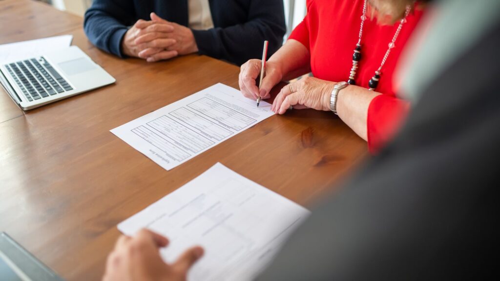 SEO local para franquicias: quién controla las fichas, la web y las reseñas 3 Firma de un contrato sobre una mesa de madera: acordar en el contrato de franquicia quién controla la ficha de Google